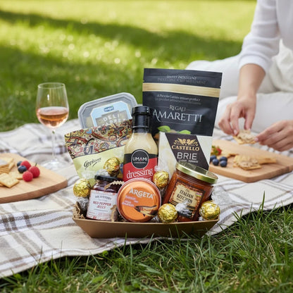 Kelowna Baskets gluten-free gift basket featuring artisanal snacks, sauces, and chocolates on a picnic blanket.